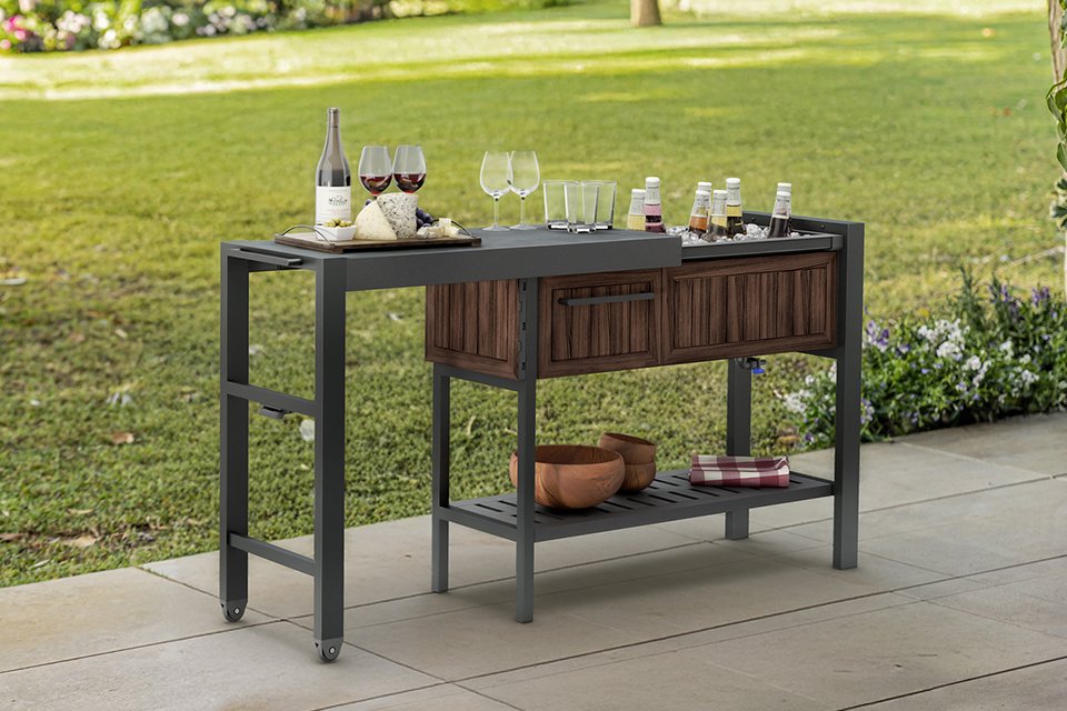 Keter Extendable Hosting Station with beverages on top and dishes on the shelf.